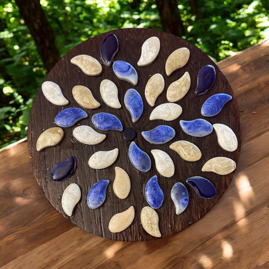 Handcrafted blue and white petal mosaic wooden plant stand with a decorative floral design for indoor or outdoor use.