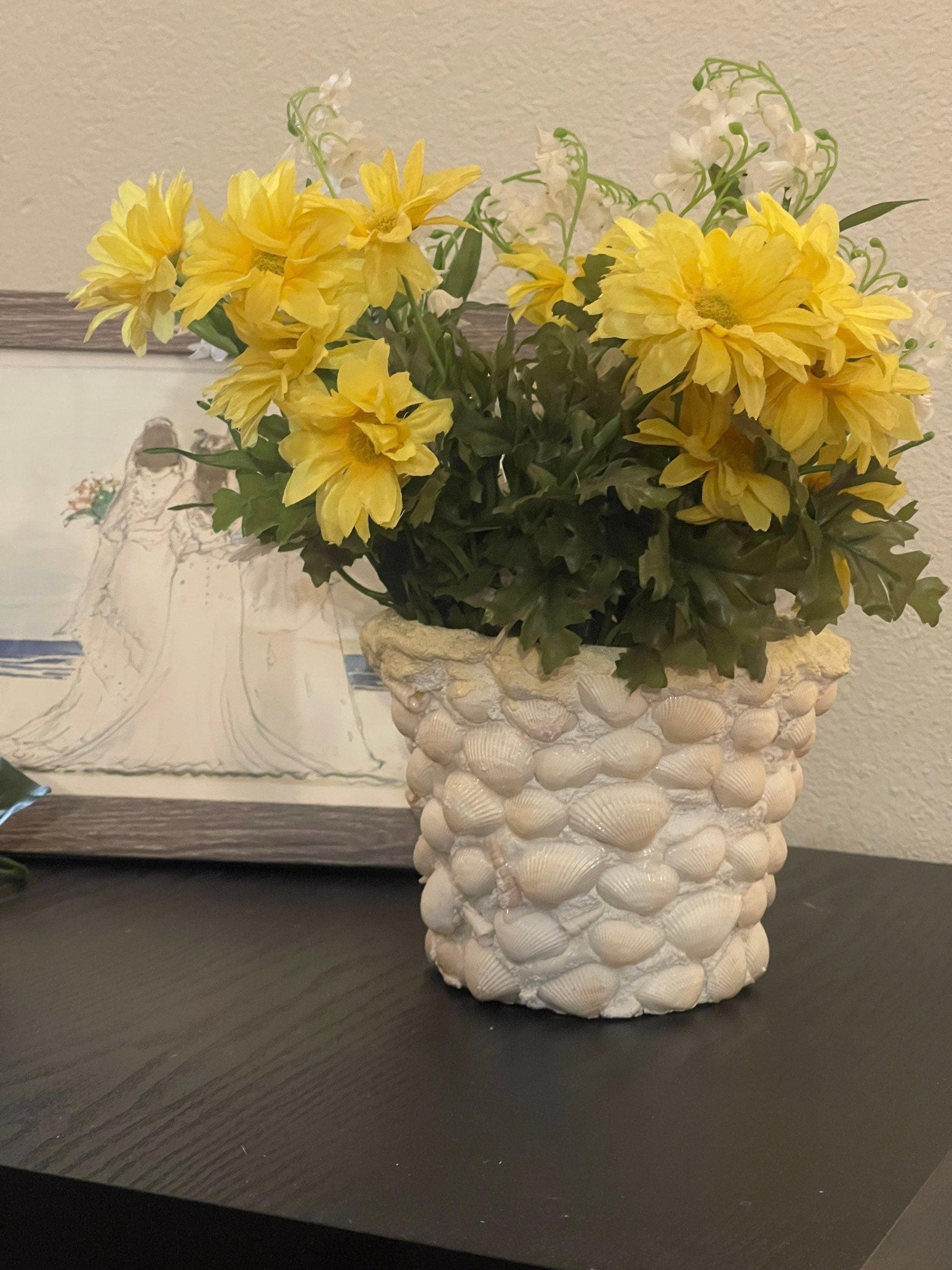 Handcrafted seashell mosaic plant pot showing intricate seashell designs on ceramic surface.