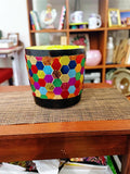 Colorful flower bouquet in a rainbow mosaic hexagon planter with lush greenery and vibrant blooms.