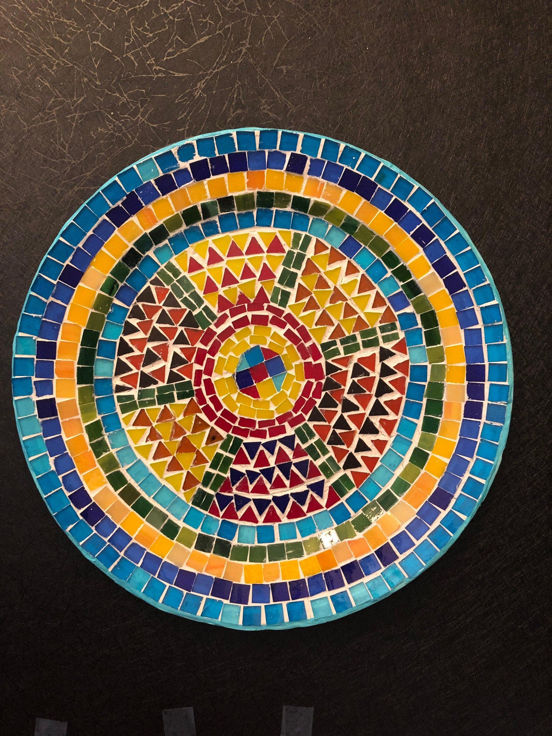 Handmade geometric mosaic plant plate with colorful tile patterns, perfect for displaying potted plants or decorative arrangements.