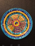 Handmade geometric mosaic plant plate with colorful tile patterns, perfect for displaying potted plants or decorative arrangements.