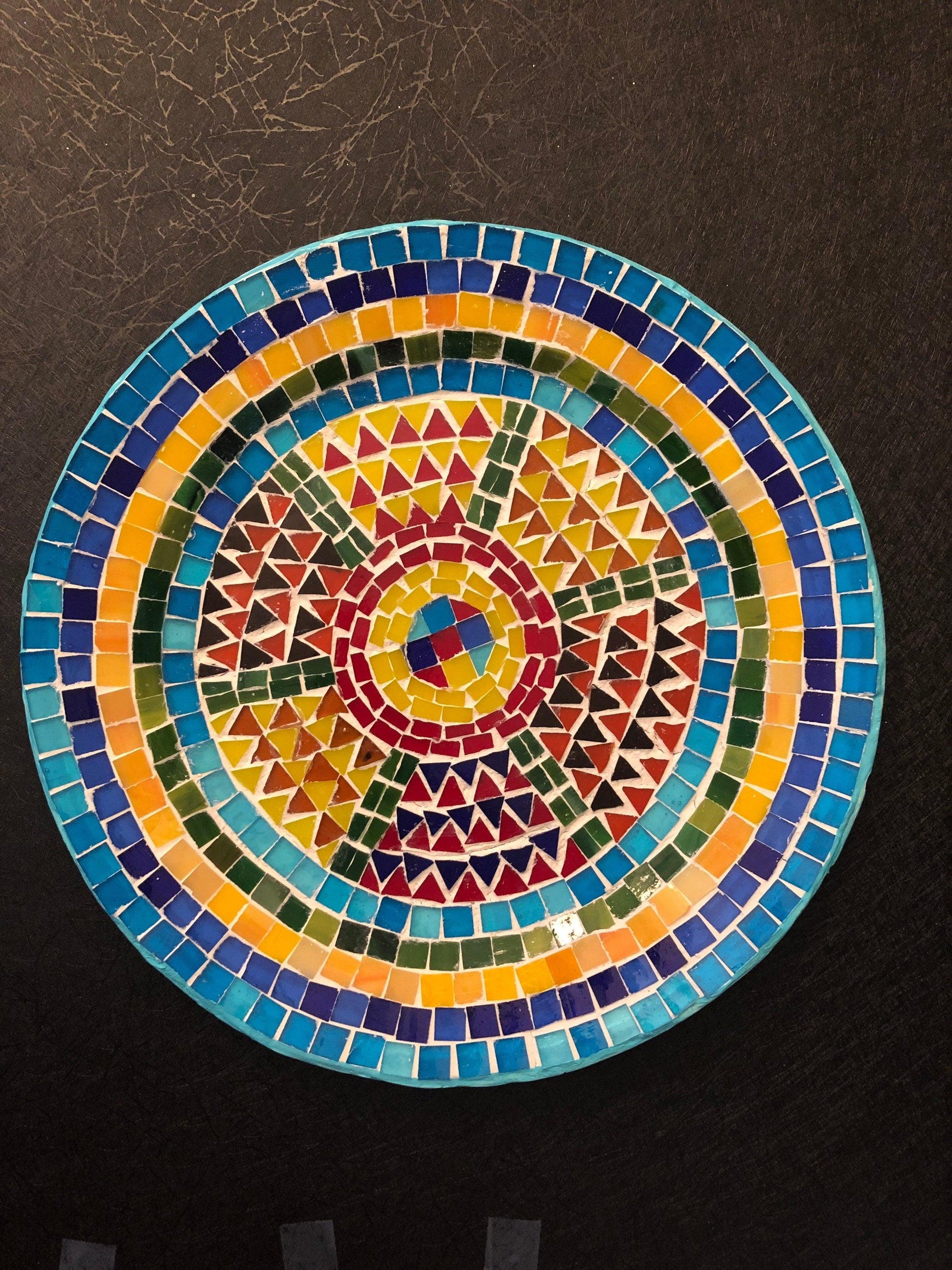 Handmade geometric mosaic plant plate with colorful tile patterns, perfect for displaying potted plants or decorative arrangements.