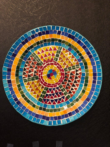 Handmade geometric mosaic plant plate with colorful tile patterns, perfect for displaying potted plants or decorative arrangements.