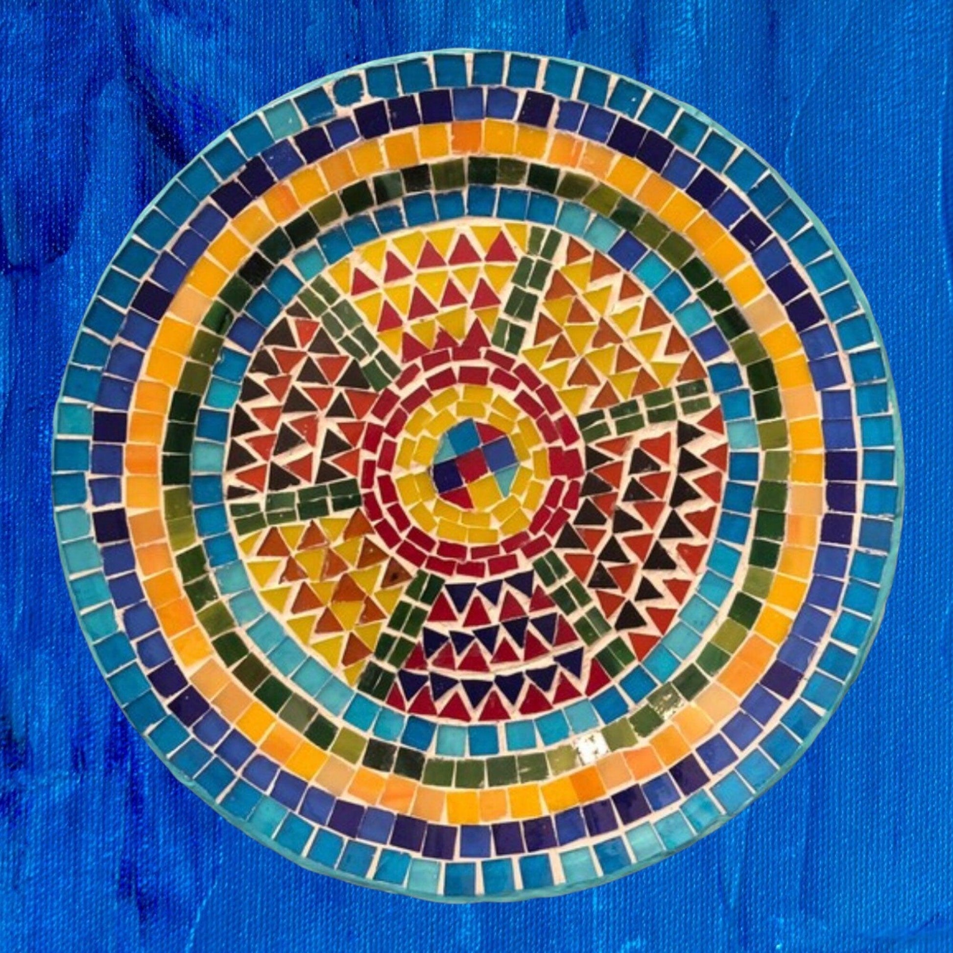 Handmade geometric mosaic plant plate with colorful tile pattern, ideal for displaying small indoor plants or succulents.