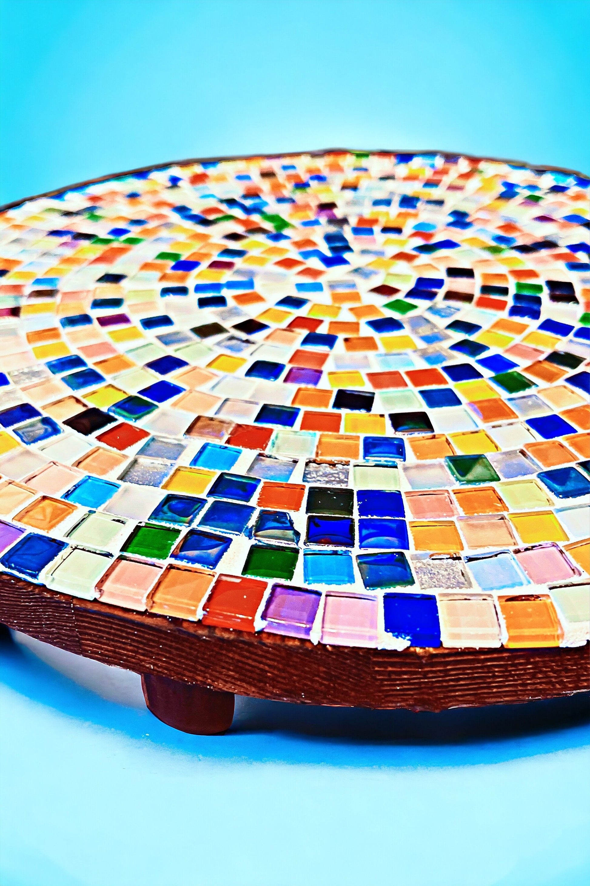 Handcrafted round rainbow mosaic plant stand with colorful tile design, perfect for displaying indoor plants.