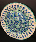 Iridescent turquoise mosaic glass wall art featuring colorful, reflective glass pieces arranged in an intricate pattern.