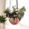 Hanging disco ball planter by Miss Bette's Creations with artificial pink carnations inside, shiny reflective surface, decorative display