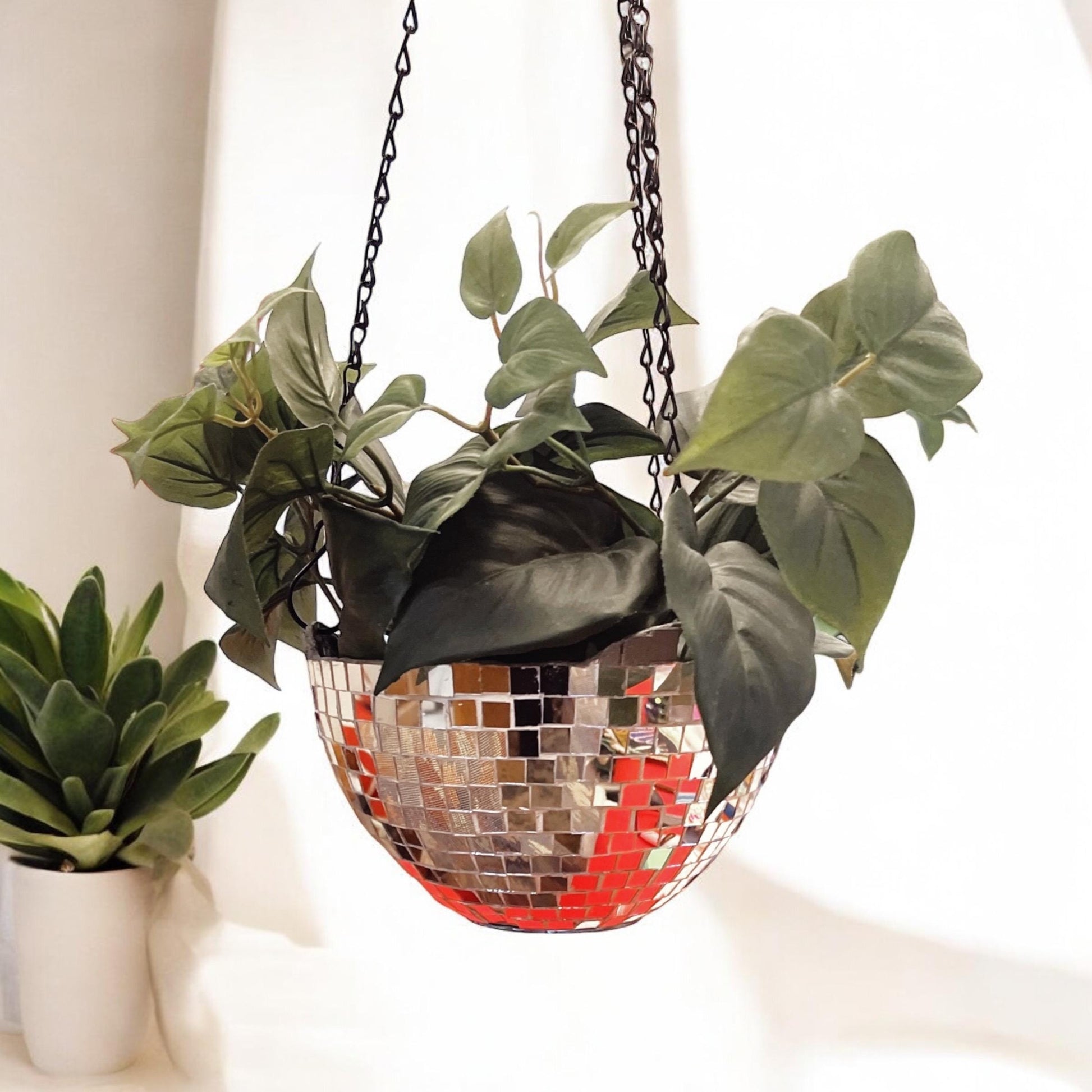 Hanging disco ball planter by Miss Bette's Creations with artificial pink carnations inside, shiny reflective surface, decorative display