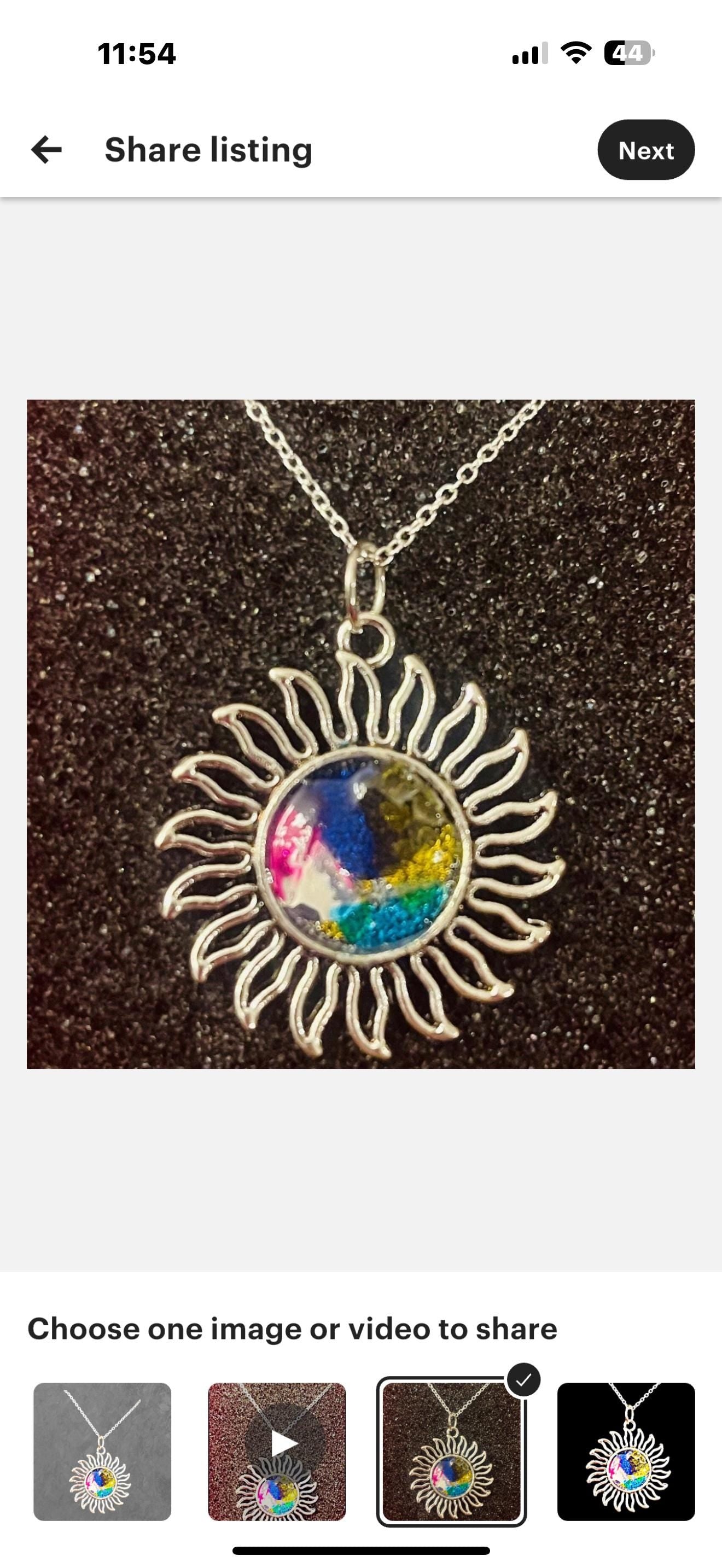 Multicolored glass Sunburst pendant necklace with silver chain, featuring vibrant stained glass design and intricate craftsmanship.