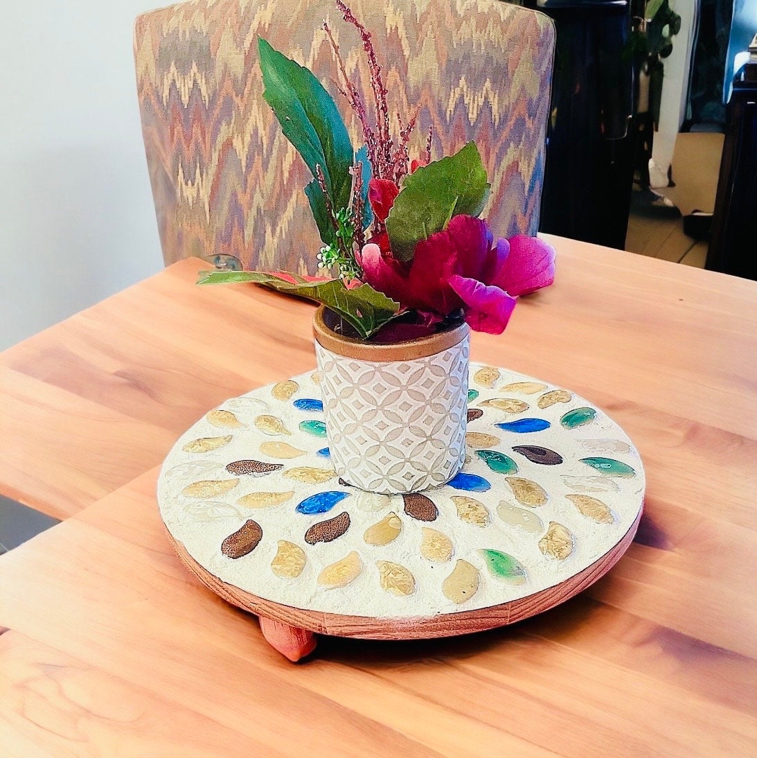 Handcrafted earth tone mosaic plant stand with multiple legs, designed for supporting potted plants in a stylish, artistic display.