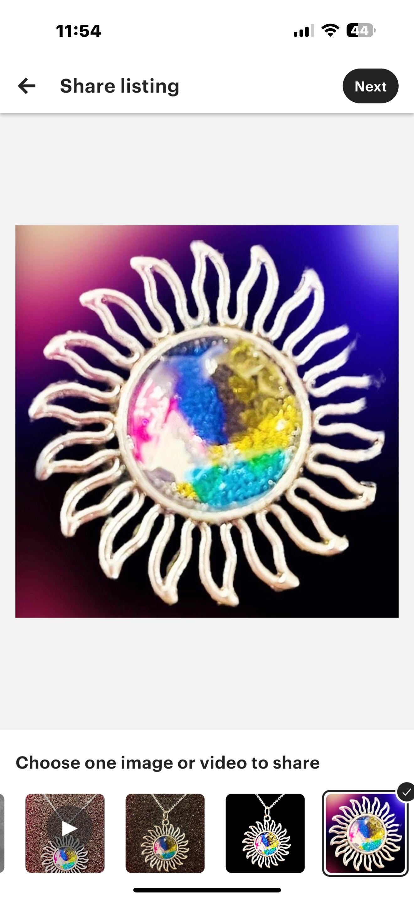 Multicolored glass sunburst pendant necklace with silver chain, featuring stained glass design and vibrant hues.