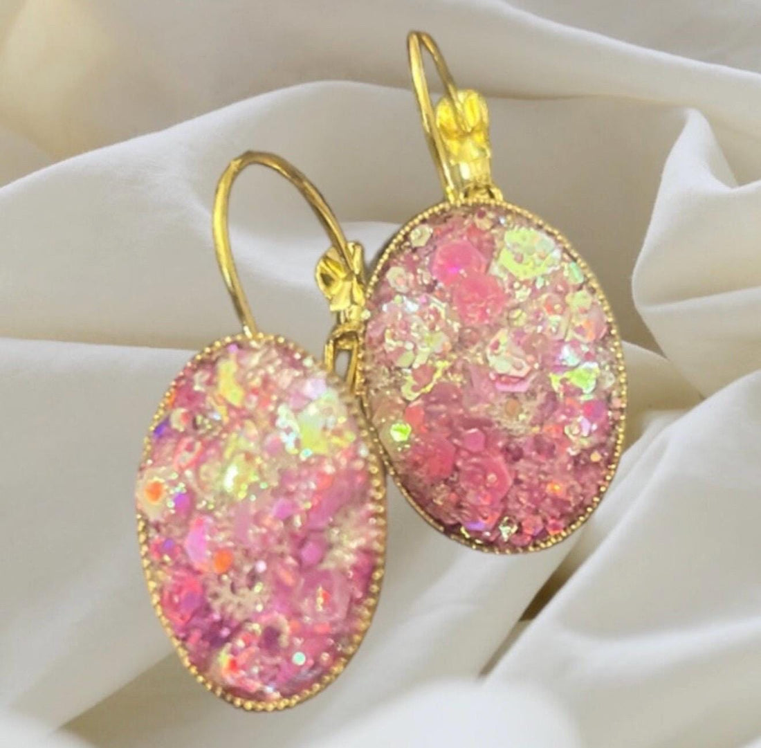 Pink iridescent glass crystal earrings with stainless steel gold posts, showcasing shimmering facets and elegant design.