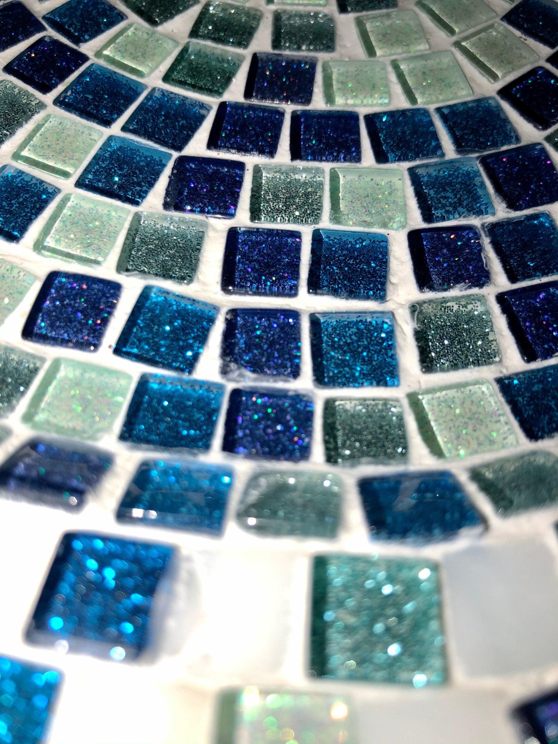 Iridescent turquoise mosaic glass wall art with geometric pattern, vibrant colors, and reflective surface for modern home decor.