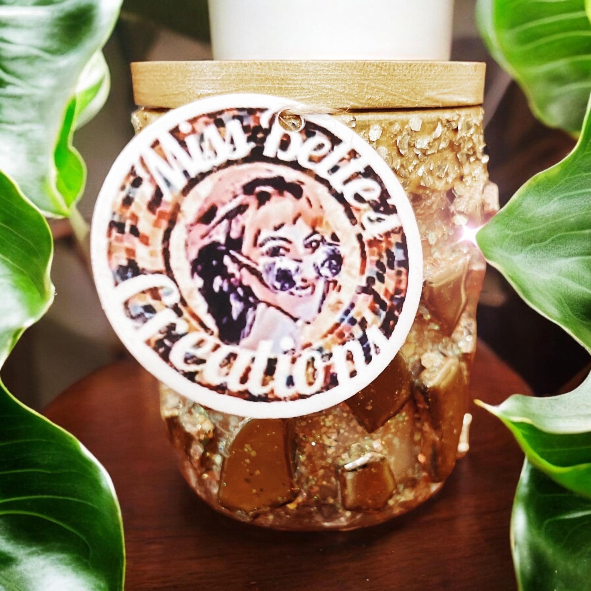 Handmade eucalyptus scented candle in a gold mosaic glass jar, held in hand, showcasing artisanal craftsmanship and elegant design.