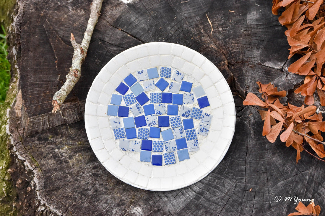 Blue and white handcrafted mosaic plate with intricate patterns, showcasing elegant design and fine craftsmanship.