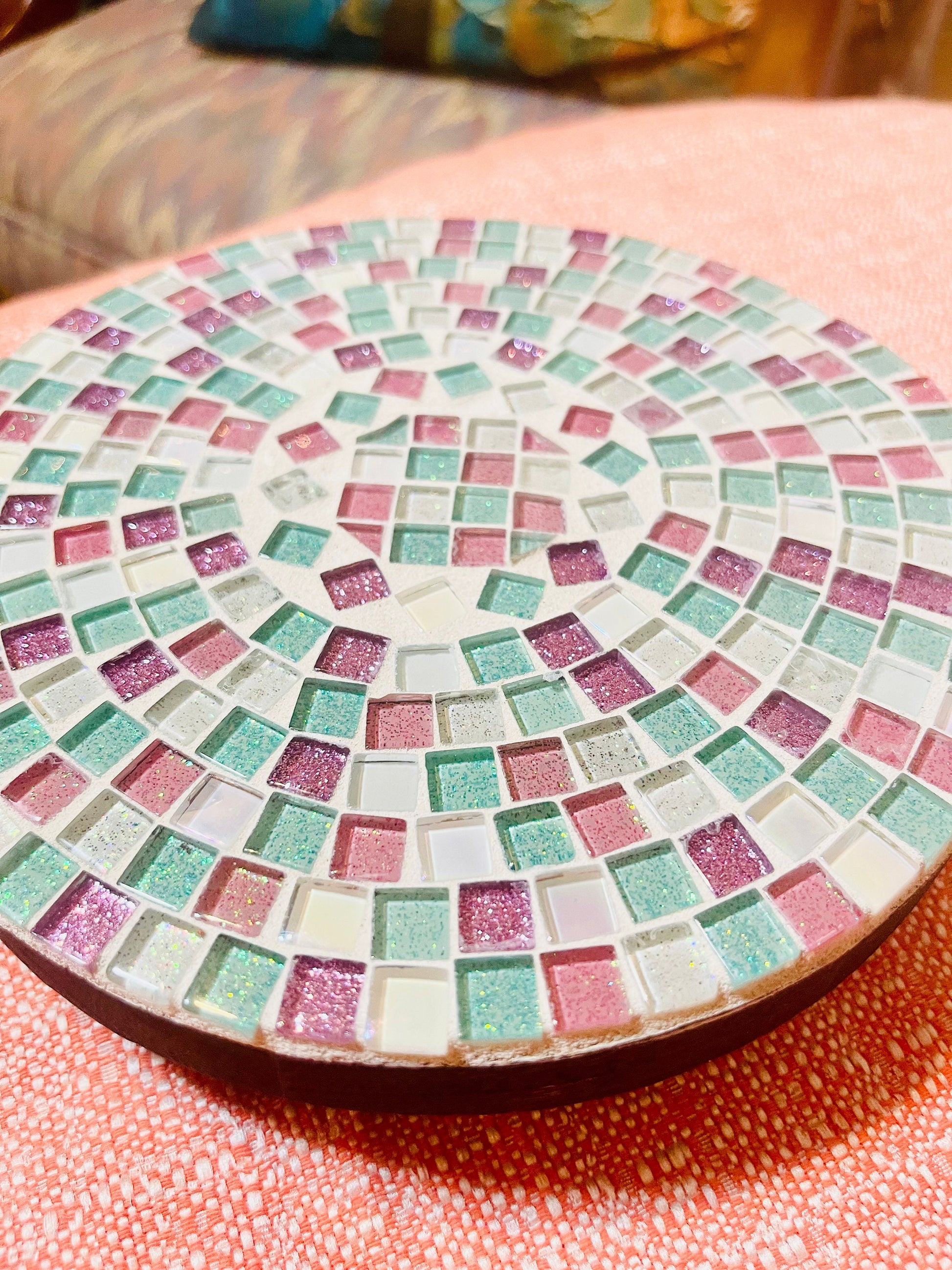 Handcrafted pink and green mosaic plant stand by Miss Bette's Creations with intricate tile patterns and sturdy metal legs.