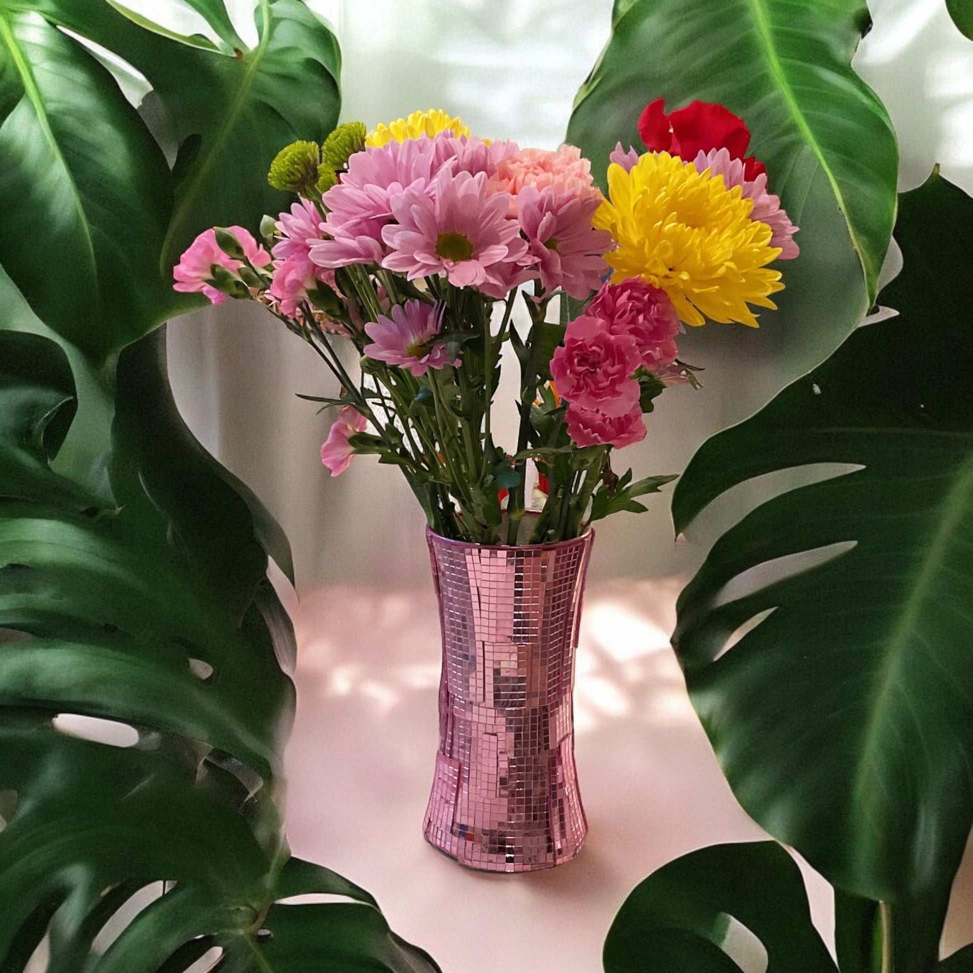 Handcrafted pink disco ball mirror vase featuring reflective mirrored surfaces and a rounded shape, perfect for decorative display.