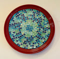 Ocean Breeze mosaic design on a deep crimson ceramic plate, featuring vibrant, intricate patterns and a glossy finish.