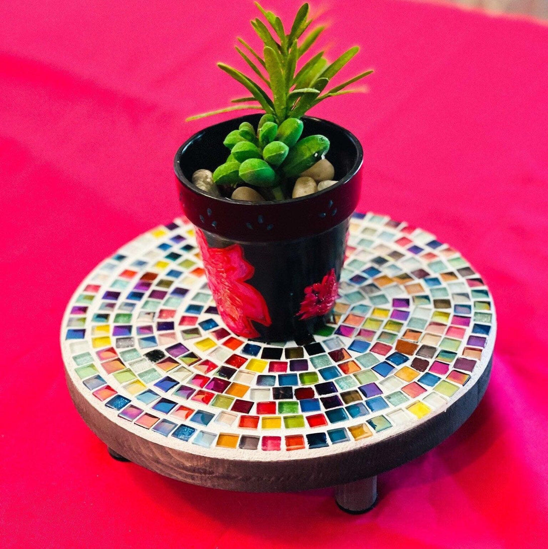 Rainbow glass tile plant stand with colorful glass tiles and metal frame, designed to hold potted plants.