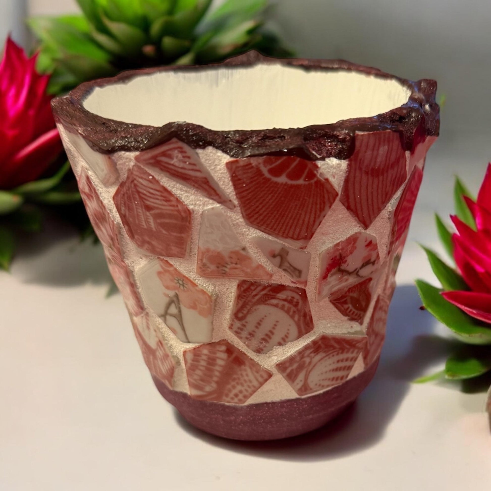 Handcrafted broken china mosaic flower pot with colorful floral design, showcasing vibrant mosaic patterns on a decorative garden planter.