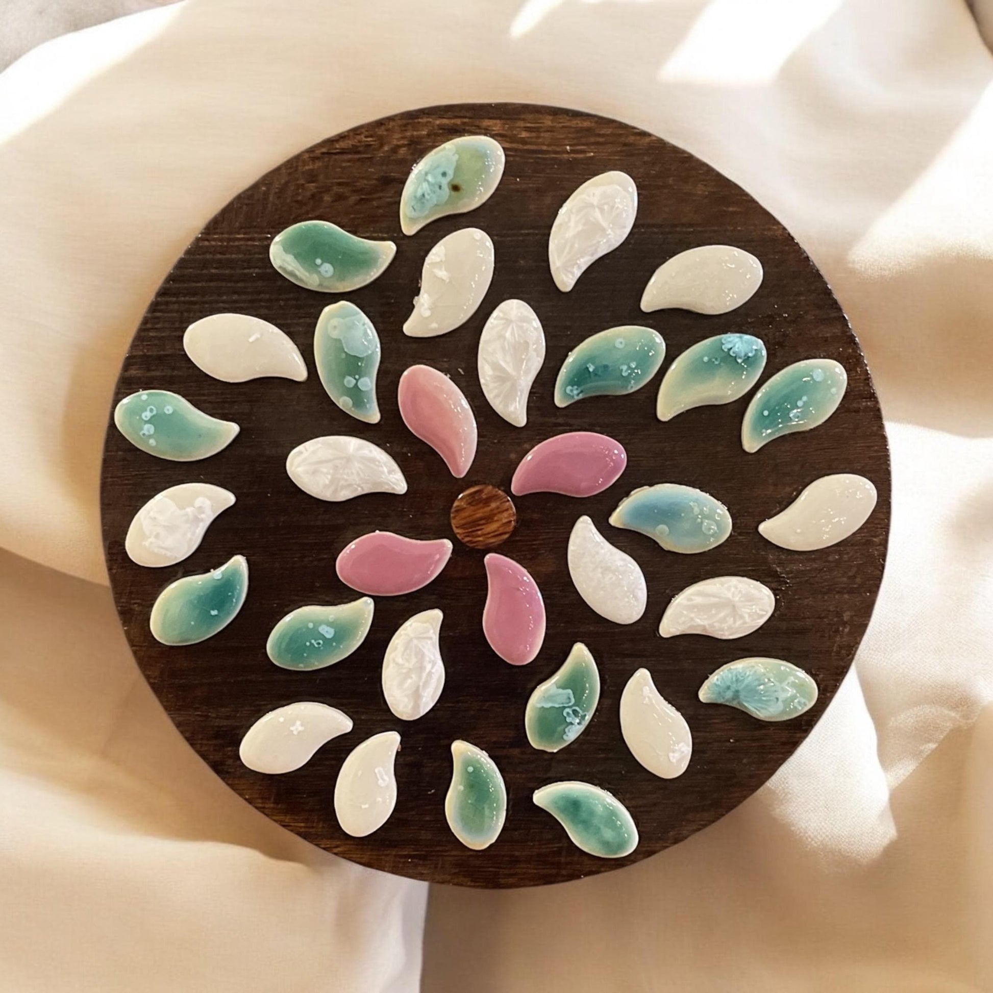 Handcrafted petal mosaic wooden plant stand with colorful floral design, perfect for indoor or outdoor plant displays.