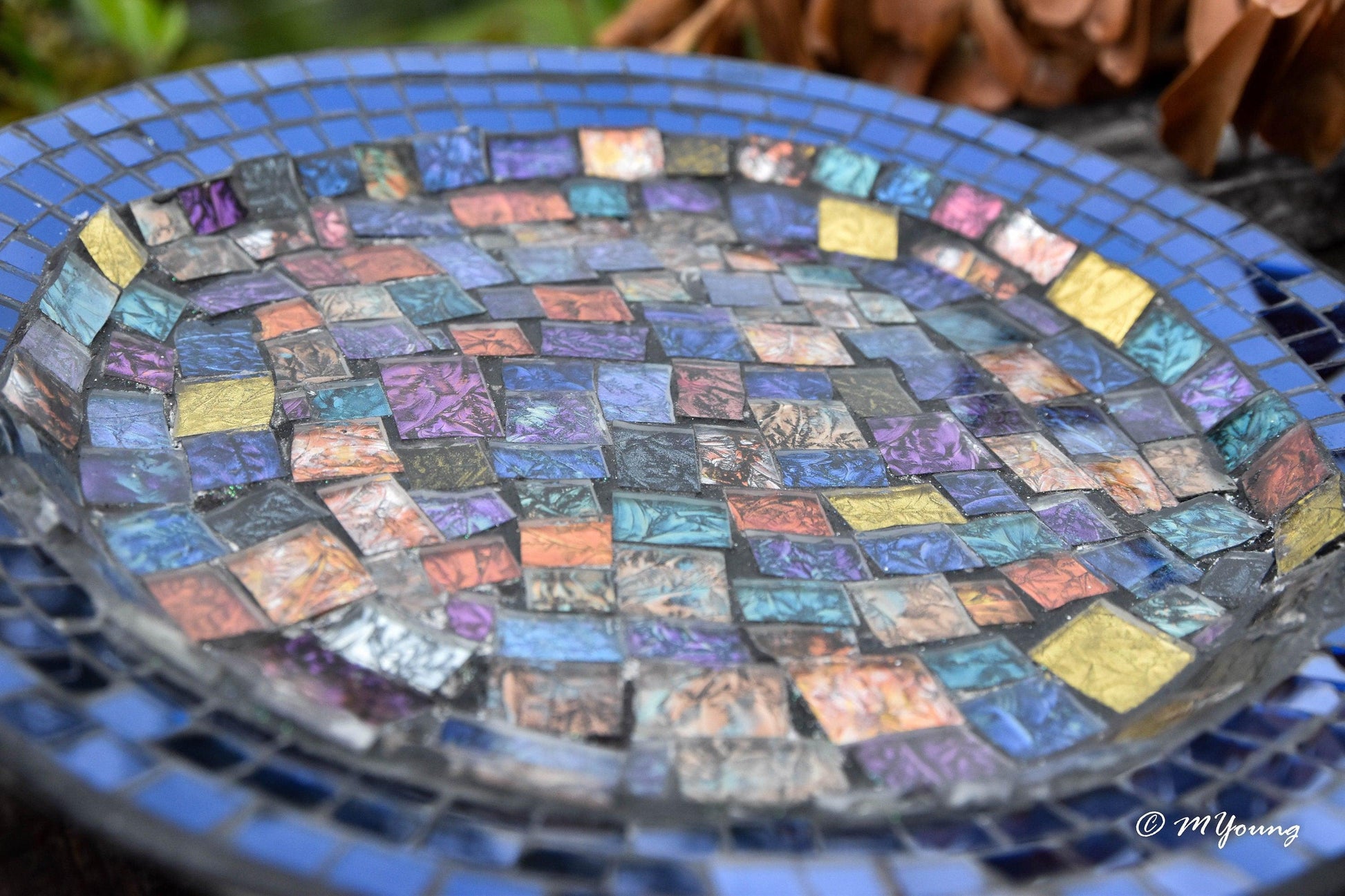 Iridescent blue glass mosaic wall art featuring shimmering blue tiles arranged in an abstract pattern for home decor.