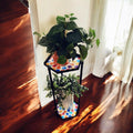 Handcrafted 2-tier rainbow mosaic plant stand with colorful tiled shelves for indoor or outdoor plants.