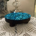 Artisanal turquoise mosaic plant stand by Miss Bette's Creations with intricate tile patterns and sturdy metal legs.