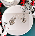 Triple layer heart dangle earrings with gold finish, featuring three connected heart charms hanging from delicate hooks.