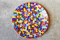 Colorful rainbow mosaic decorative wall plate with vibrant geometric patterns, perfect for wall decor.