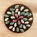 Handcrafted petal mosaic wooden plant stand with intricate floral design, perfect for displaying indoor plants.