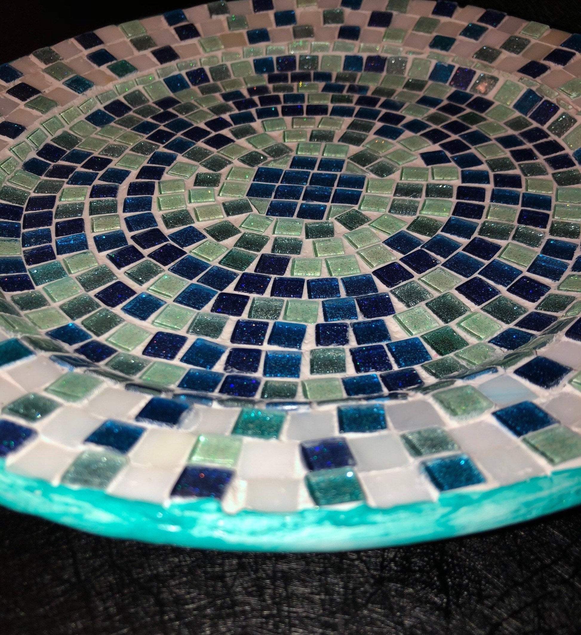 Iridescent turquoise mosaic glass wall art with shimmering tiles, showcasing vibrant colors and intricate design.