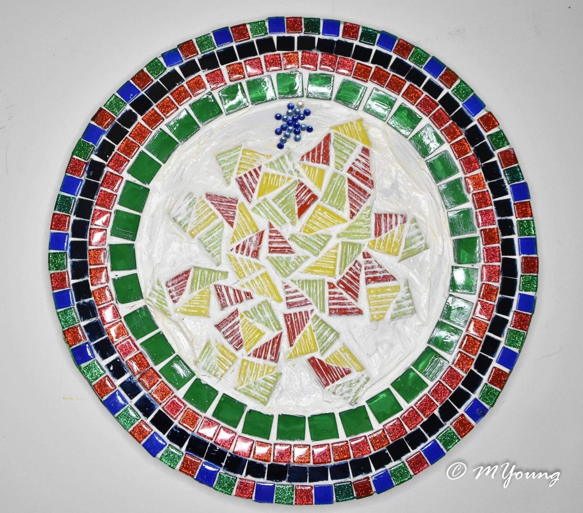 Handcrafted round mosaic decorative plate with colorful geometric patterns, artisan-made, showcasing intricate tile work.