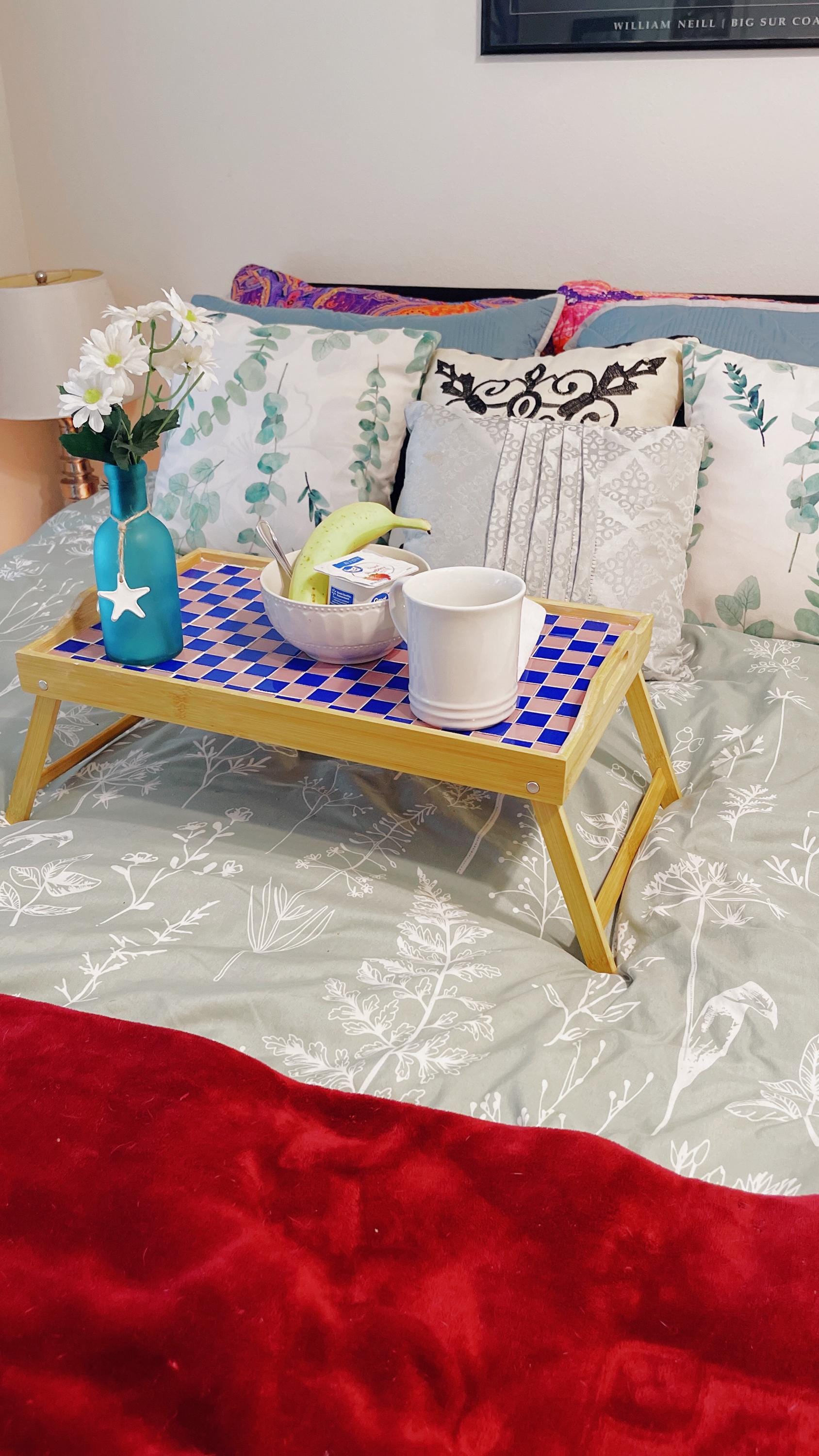 Handcrafted bamboo laptop tray with pink cushion, designed for comfortable workspace and portable use.