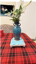 Square turquoise ceramic plant stand with handmade design, perfect for displaying potted plants in a stylish home decor setting.