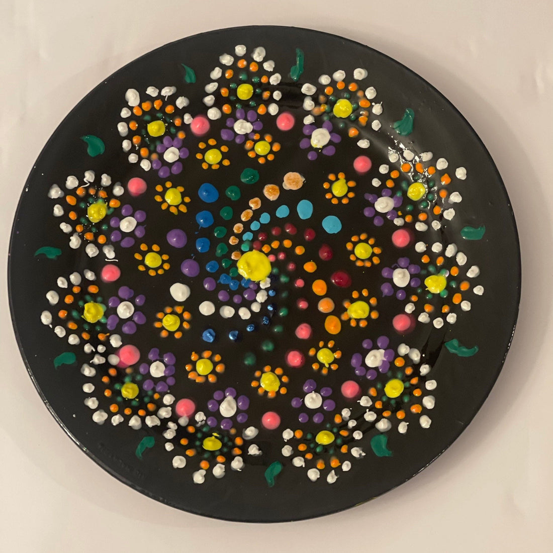 Handmade Mandala dot painting on black glass plate with intricate colorful patterns and detailed design.