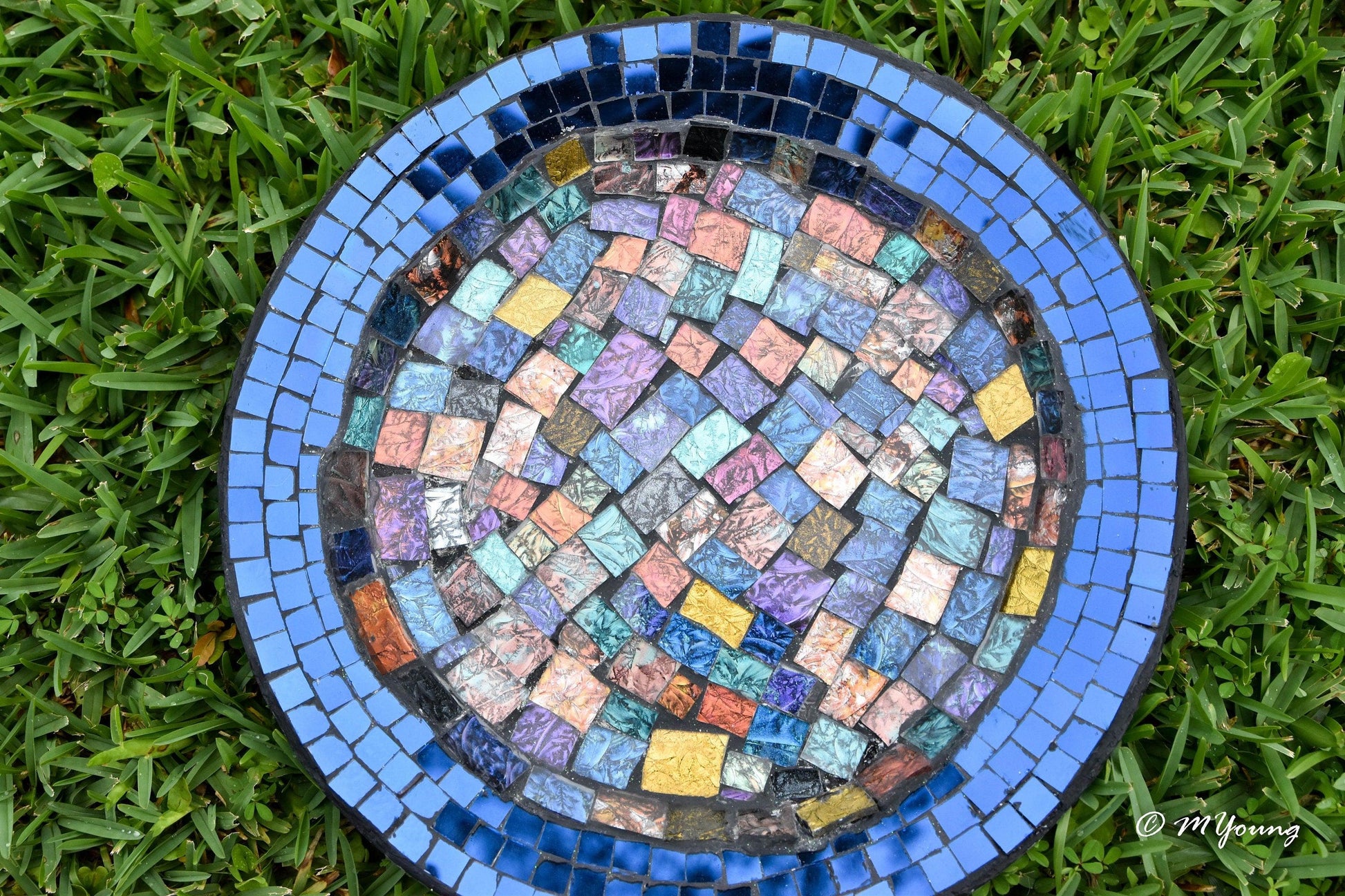 Iridescent blue glass mosaic wall art featuring shimmering geometric patterns, perfect for modern home decor.