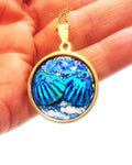 Ocean blue shell medallion necklace featuring a large shell pendant on a delicate chain, showcasing natural ocean-inspired design.