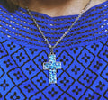 Sparkling blue crystal cross necklace with silver chain, elegant jewelry piece featuring dazzling blue gemstones and intricate design.