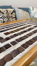Rustic bamboo bed tray with stone mosaic inlay, featuring handles for serving and a natural finish for a stylish, functional piece.