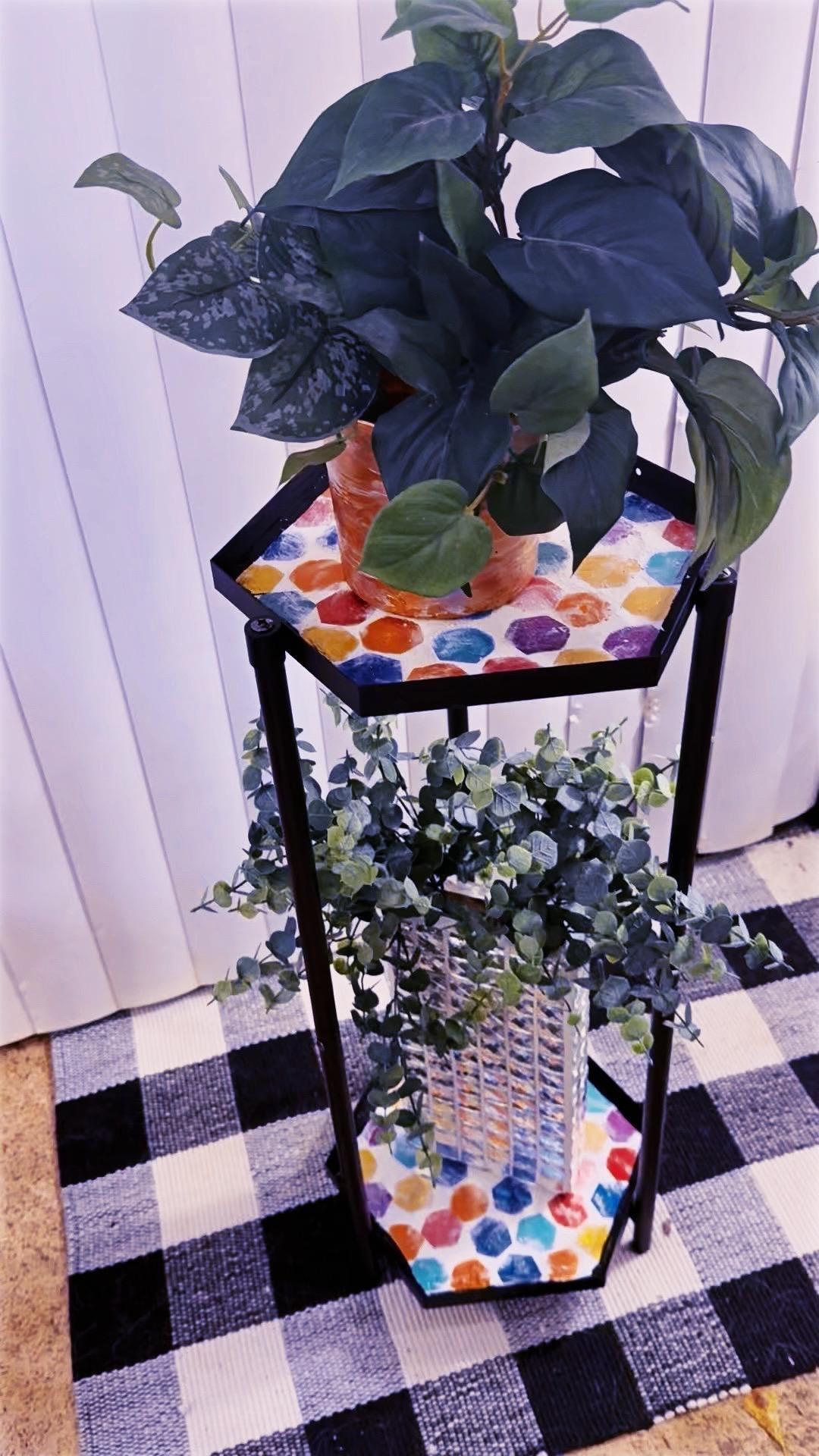 Handcrafted 2-tier rainbow mosaic plant stand with vibrant tiles and sturdy metal frame for indoor or outdoor use.
