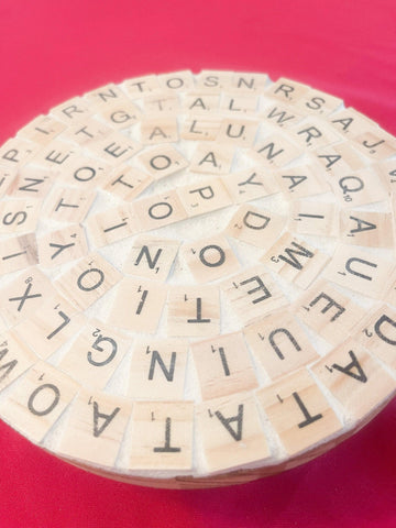 Decorative word game-themed plant stand with wooden letters and greenery, perfect for modern home plant decor.