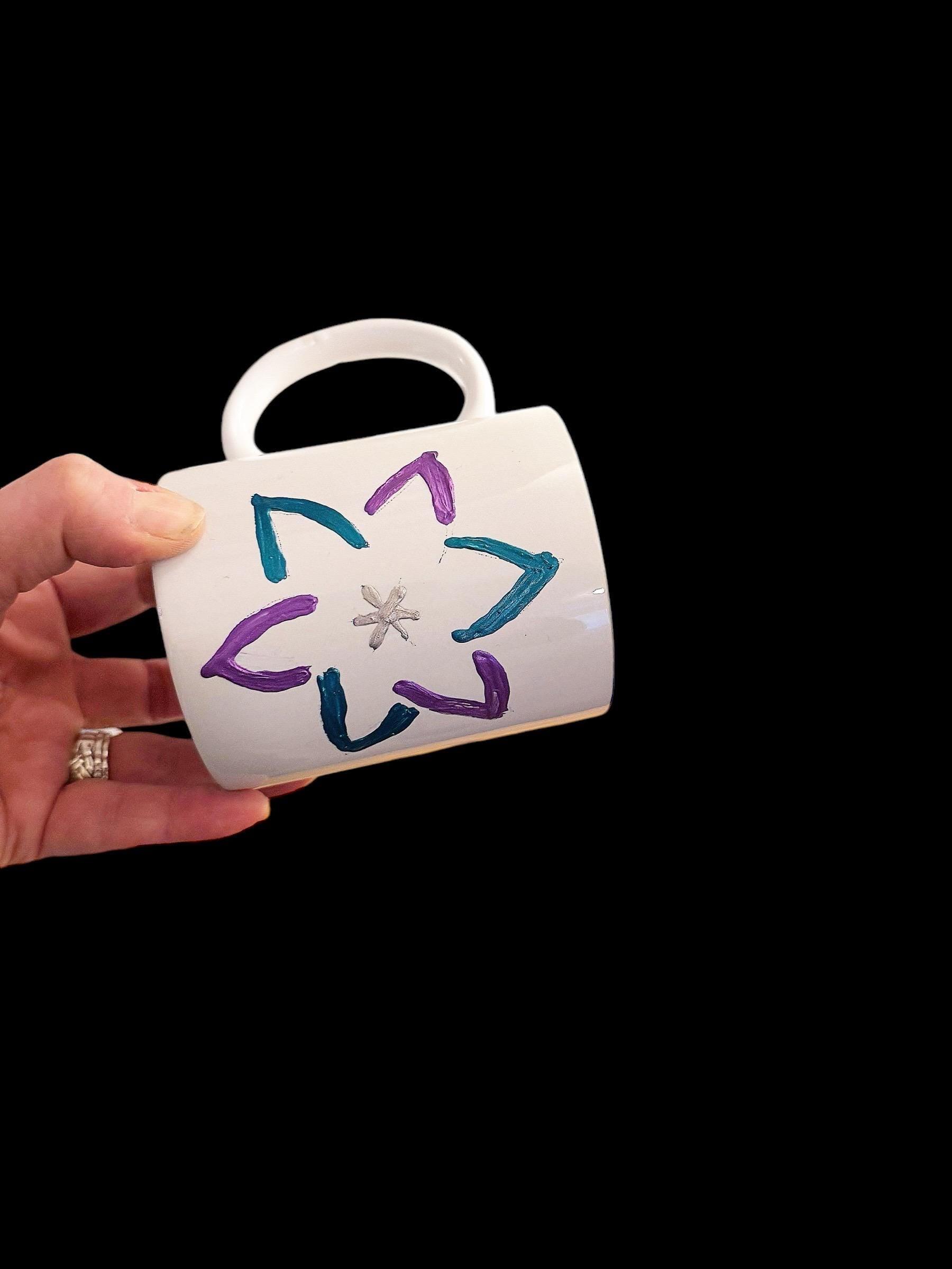 Handpainted coffee mug with colorful floral design from My Store, showcasing detailed artwork on a ceramic mug.
