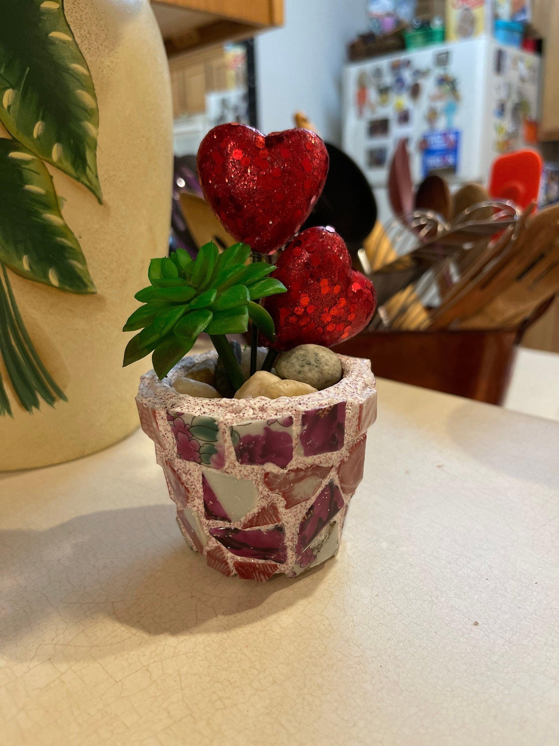 Handcrafted broken china heart mosaic planter with colorful ceramic pieces, suitable for indoor or outdoor decorative plant display.
