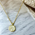 Iridescent shell resin circle pendant with a shiny, colorful finish, featuring a smooth, rounded design for jewelry or accessories.