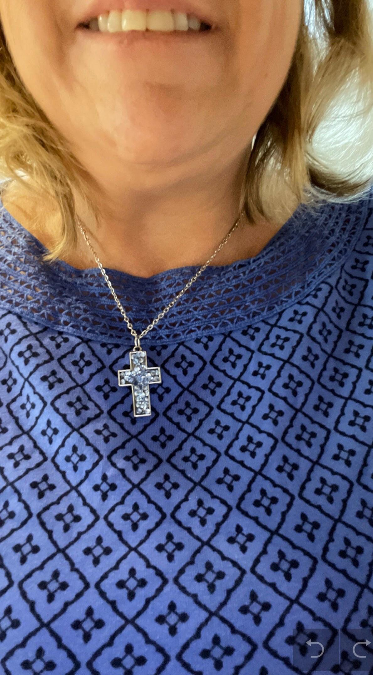 Sparkling blue crystal cross necklace with silver chain, elegant jewelry accessory featuring a vibrant blue crystal cross pendant.