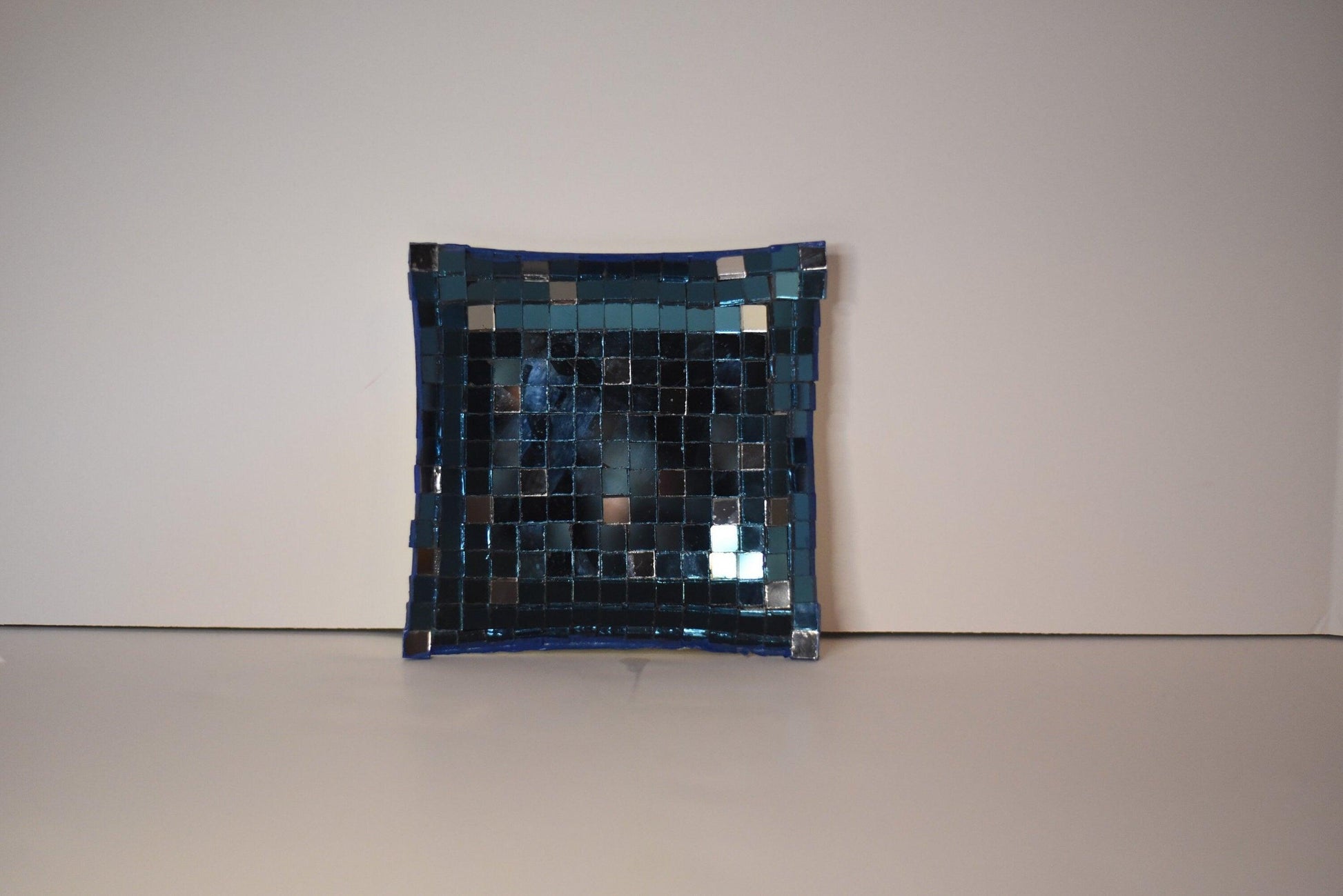 Handcrafted mosaic mirror glass dish with colorful geometric patterns, showcasing intricate design and reflective surface.