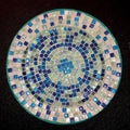 Iridescent turquoise mosaic glass wall art with vibrant, shimmering tiles arranged in an intricate pattern.