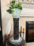 Handcrafted mosaic pedestal planter with colorful tile design, elevated on a decorative stand, ideal for indoor or outdoor plants.
