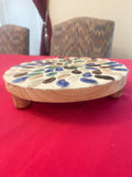 Handmade earth tone mosaic plant stand with colorful ceramic tiles, designed to hold potted plants in a stylish indoor or outdoor space.